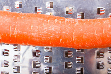 Image showing grated carrots. Nearby is grater and carrots