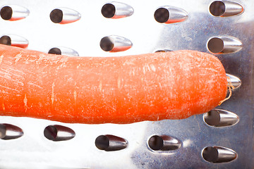 Image showing grated carrots. Nearby is grater and carrots