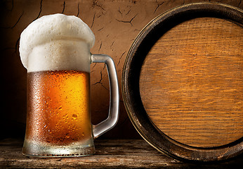 Image showing Frothy beer and barrel