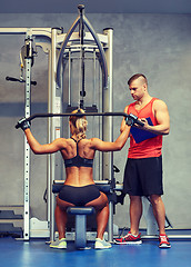 Image showing man and woman flexing muscles on gym machine