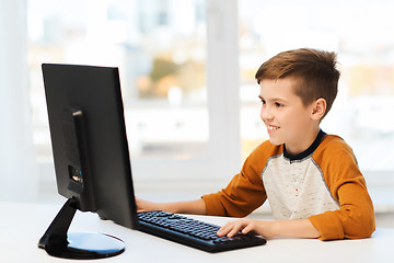 Image showing smiling boy with computer at home