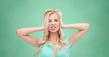 Image showing young woman holding to her head and screaming