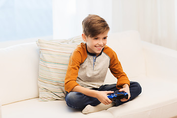 Image showing happy boy with joystick playing video game at home