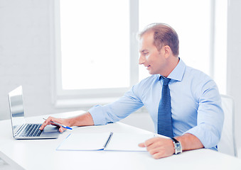 Image showing smiling businessman working in office