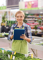 Image showing happy woman with tablet pc in greenhouse