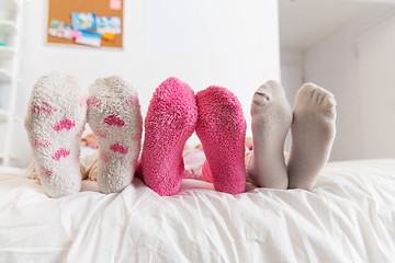 Image showing close up of women feet in socks on bed at home