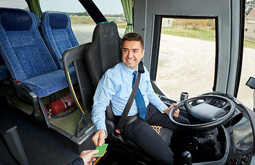 Image showing bus driver taking ticket or card from passenger