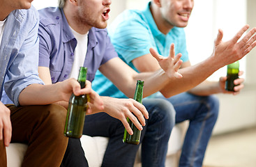 Image showing happy male friends with beer watching tv at home