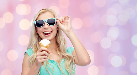 Image showing happy young woman in sunglasses eating ice cream