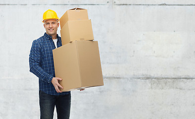 Image showing smiling man in helmet with cardboard boxes