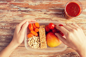 Image showing close up of hands with vegetarian food in box