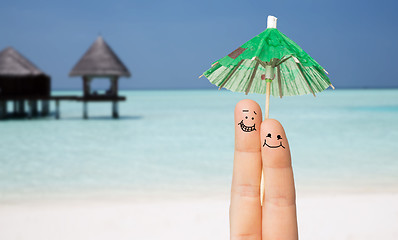 Image showing close up of two fingers with cocktail umbrella