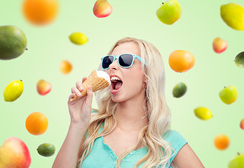 Image showing happy young woman in sunglasses eating ice cream