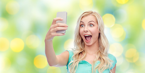 Image showing smiling young woman taking selfie with smartphone