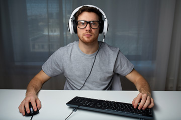 Image showing man in headset playing computer video game at home