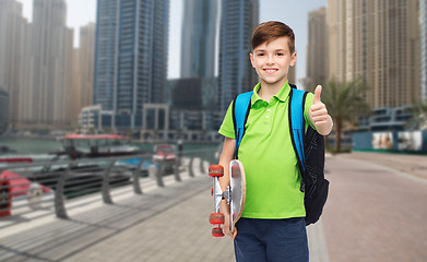 Image showing boy with backpack and skateboard showing thumbs up