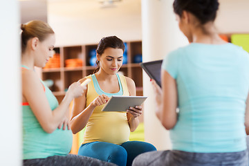 Image showing happy pregnant women with gadgets in gym