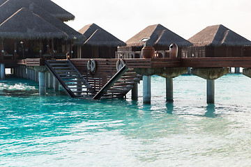 Image showing bungalow huts in sea water on exotic resort beach