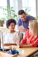 Image showing happy creative team with computer in office