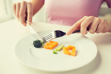 Image showing close up of woman hands eating vegetables