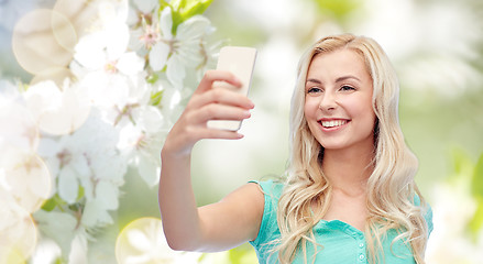 Image showing smiling young woman taking selfie with smartphone