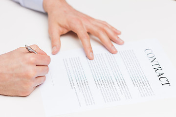 Image showing close up of male hands signing contract document