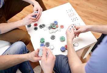 Image showing close up of male friends playing cards at home