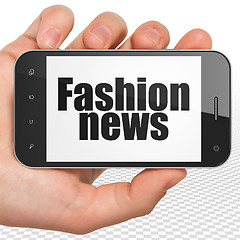 Image showing News concept: Hand Holding Smartphone with Fashion News on display