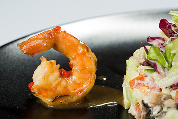 Image showing perfect dish with shrimps on a black plate. seafood