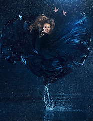 Image showing The young beautiful modern dancer dancing under water drops