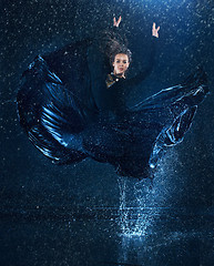 Image showing The young beautiful modern dancer dancing under water drops