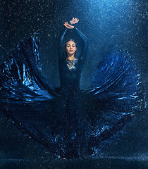 Image showing The young beautiful modern dancer dancing under water drops