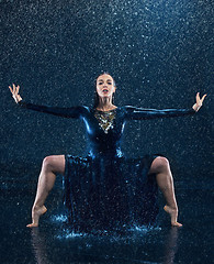 Image showing The young beautiful modern dancer dancing under water drops