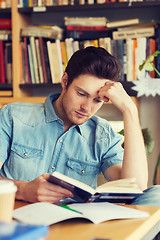 Image showing male student reading book in library