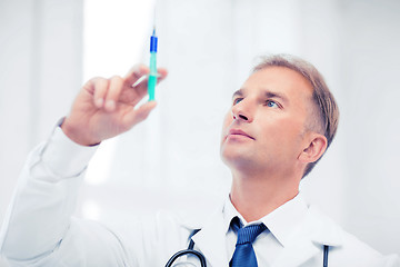 Image showing male doctor holding syringe with injection