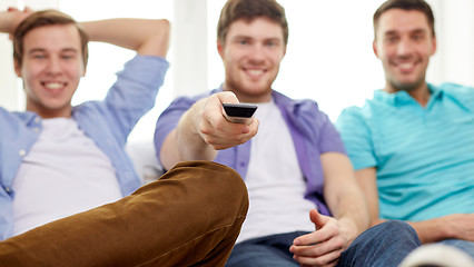 Image showing happy male friends with remote watching tv at home