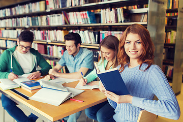 Image showing happy students reading books in library