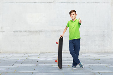 Image showing happy boy with skateboard showing thumbs up