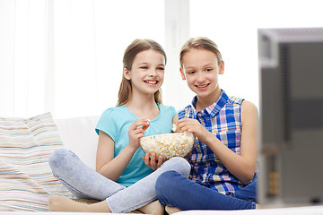 Image showing happy girls with popcorn watching tv at home