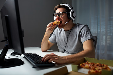 Image showing man in headset playing computer video game at home