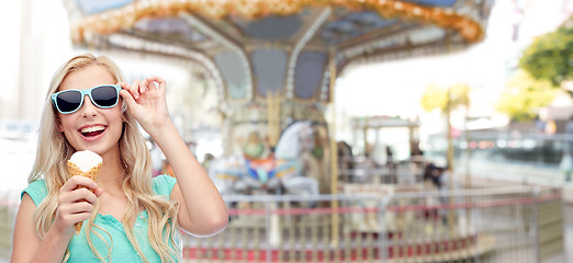 Image showing happy young woman in sunglasses eating ice cream