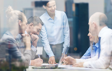 Image showing smiling female boss talking to business team