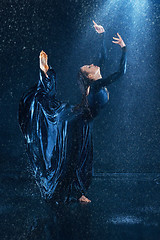 Image showing The young beautiful modern dancer dancing under water drops