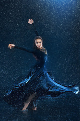 Image showing The young beautiful modern dancer dancing under water drops