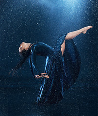 Image showing The young beautiful modern dancer dancing under water drops