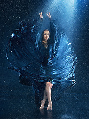 Image showing The young beautiful modern dancer dancing under water drops