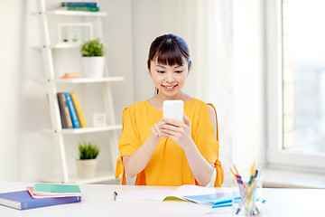 Image showing happy young woman student with smartphone at home