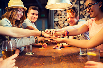 Image showing friends putting hands on top of each other at bar