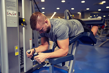 Image showing man flexing leg muscles on gym machine