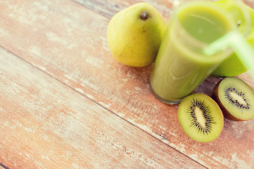 Image showing close up of fresh green juice and fruits on table